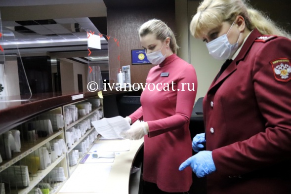 инспектор Роспотребнадзора с планшетом осматривает помещение